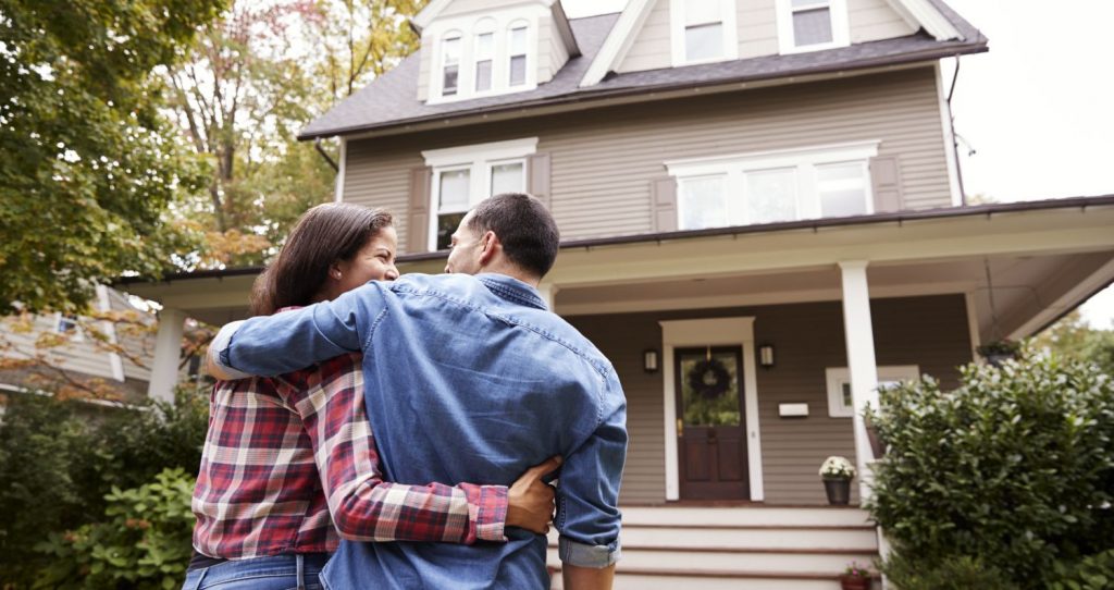 Couple in front of home