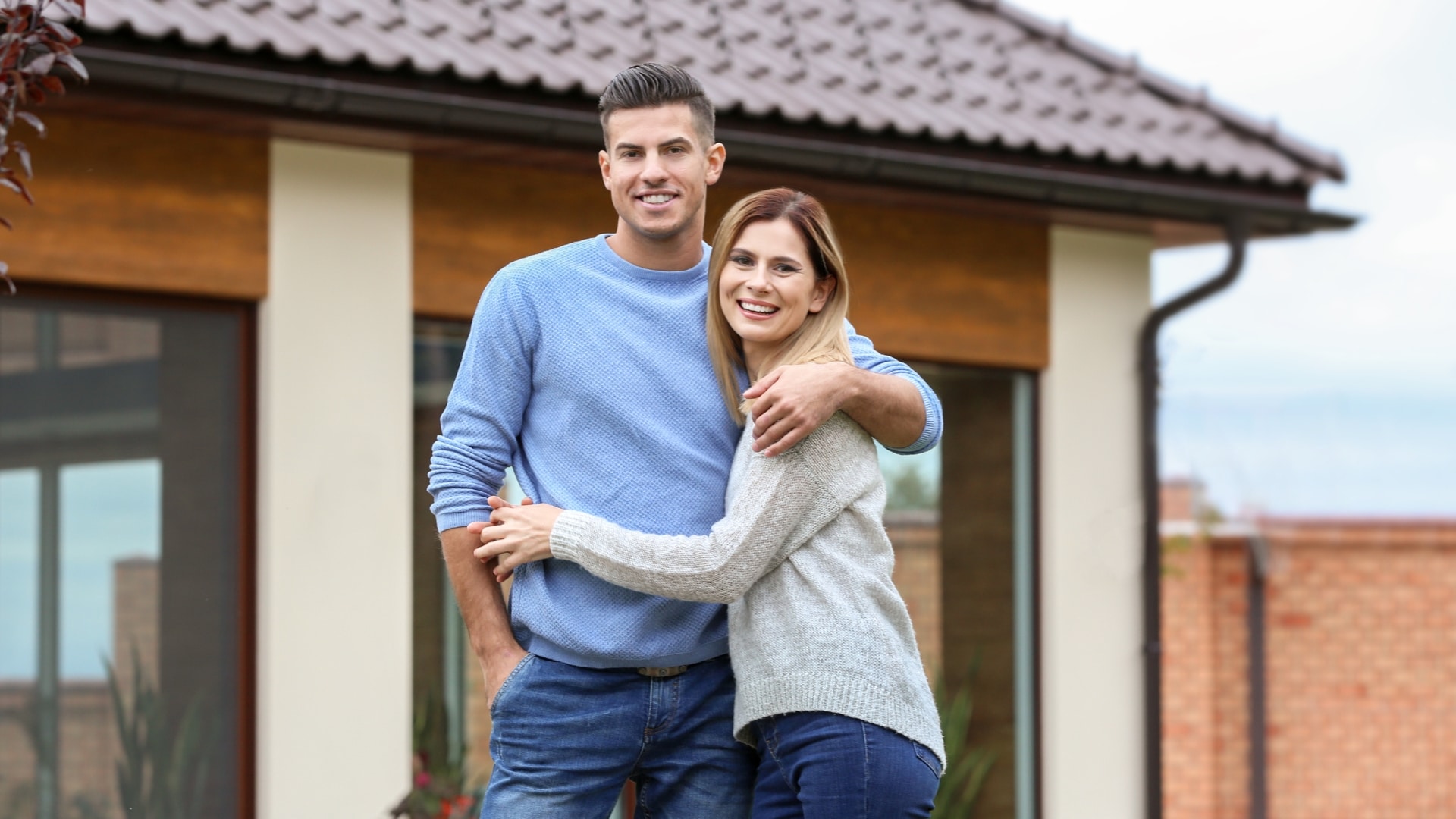 Couple in front of their new home.